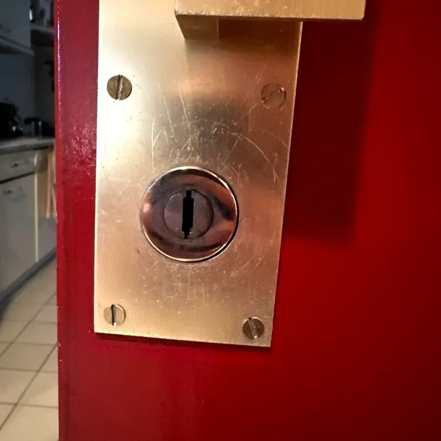 Applique laiton et cylindre sur porte rouge, dépannage d’urgence à Lyon
